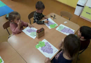 Dzieci z fioletowych kółek wykonują winogron.